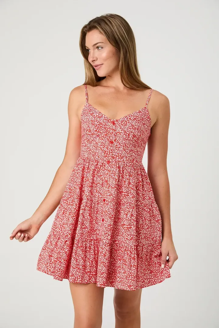 A model wearing a red and white floral print tiered mini dress from Madison's Niche